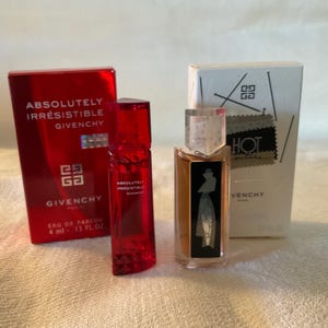 May include: Two miniature perfume bottles, one red and one clear with a black label. The red bottle has the text "Absolutely Irresistible Givenchy" on the label. The clear bottle has the text "Hot" on the label. Both bottles are 4 ml.