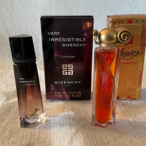 May include: Three perfume bottles and boxes. The bottles are labelled "Very Irrésistible Givenchy" and "Organza Givenchy". The boxes are black and gold, with the Givenchy logo. The perfume bottles are various shapes and sizes.