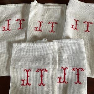 Può includere: Set di sei asciugamani da cucina bianchi con iniziali ricamate in rosso "JT".