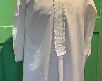 May include: A white cotton nightgown with a lace trim around the collar and down the front. The nightgown has a button closure and a small embroidered design on the chest.