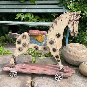 Fabulous vintage french painted wood horse on wheels.