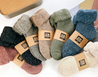 Puede incluir: Surtido de ocho pares de calcetines de lana acogedores en varios colores y patrones, incluyendo marrón, verde, azul y beige. Cada calcetín tiene una etiqueta marrón con el texto "Top Dog" impreso en ella.