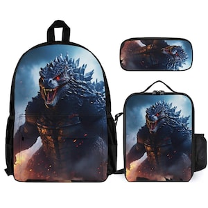 May include: A three-piece school set featuring a black backpack, lunch bag, and pencil case. All three pieces feature a graphic print of a Godzilla-like monster with red eyes and a fiery background.