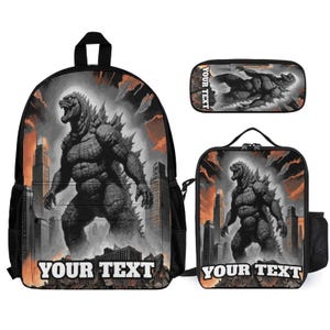 May include: A backpack, a lunch bag, and a pencil case set featuring a graphic of a large, grey, reptilian monster standing in a city with orange and black smoke. Each item includes the text YOUR TEXT printed in white at the bottom.