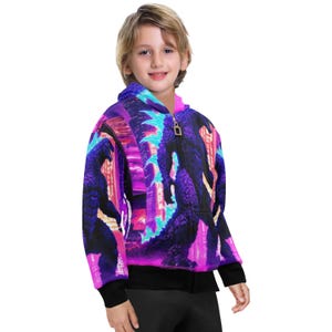 Op de afbeelding: Een zwarte hoodie met rits en een kleurrijke print van een monster in een stad. De print heeft neon roze, blauwe en paarse kleuren.