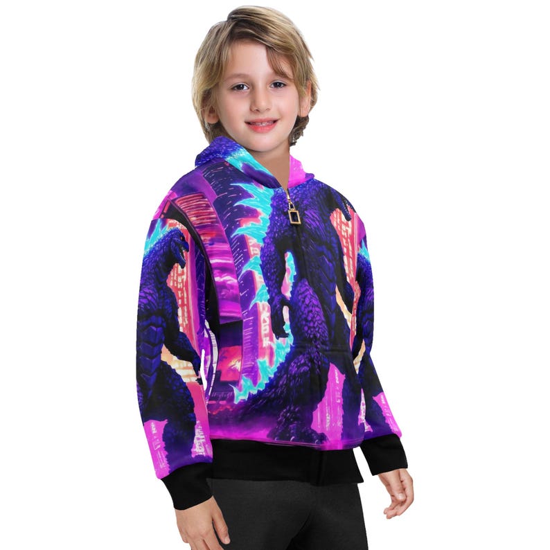 Op de afbeelding: Een zwarte hoodie met rits en een kleurrijke print van een monster in een stad. De print heeft neon roze, blauwe en paarse kleuren.