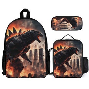 May include: A black backpack, lunch bag, and pencil case set featuring a Godzilla-like monster with red eyes and a fiery background. The monster is standing in front of a city skyline.