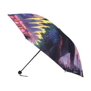 May include: A black and blue umbrella with a Godzilla graphic. The umbrella features a cityscape with neon lights and a Godzilla monster in the background.