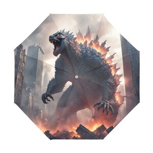 以下が含まれることがあります： 都市の背景に黒いゴジラモンスターの傘。モンスターは背後から炎を上げて吠えている