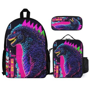 May include: A three-piece school set featuring a black backpack, lunch bag, and pencil case. All three pieces feature a colorful graphic of a Godzilla-like monster in a neon cityscape.