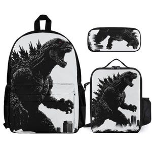 May include: A black and white Godzilla-themed backpack, pencil case, and lunch bag set. The backpack features a large graphic of Godzilla roaring over a cityscape. The lunch bag and pencil case also have Godzilla graphics.