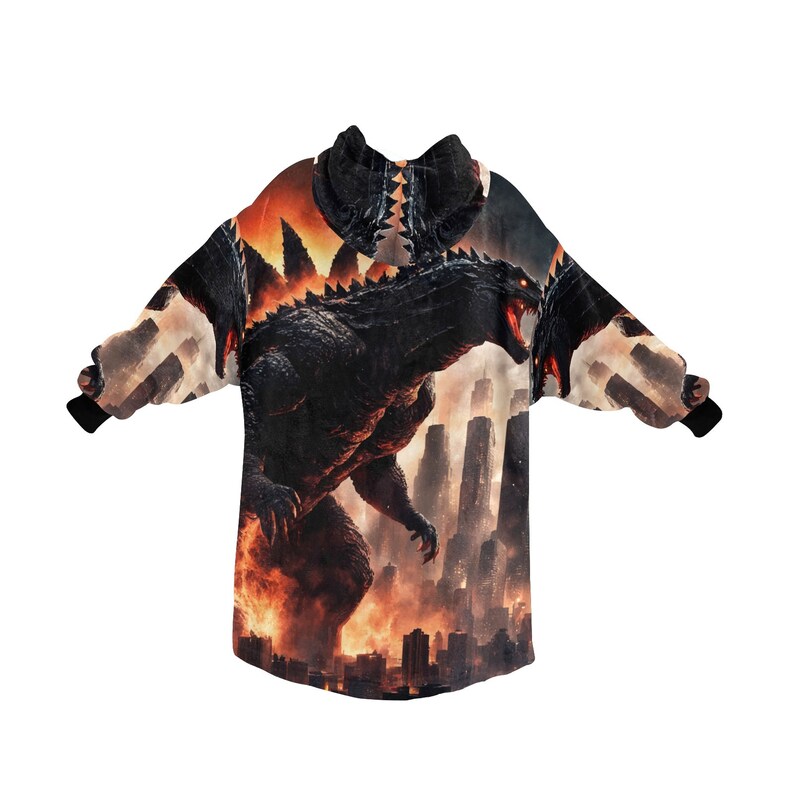 May include: A hooded sweatshirt featuring a Godzilla graphic. The design shows Godzilla roaring in front of a city skyline engulfed in flames. The color palette includes black, orange, and gray.