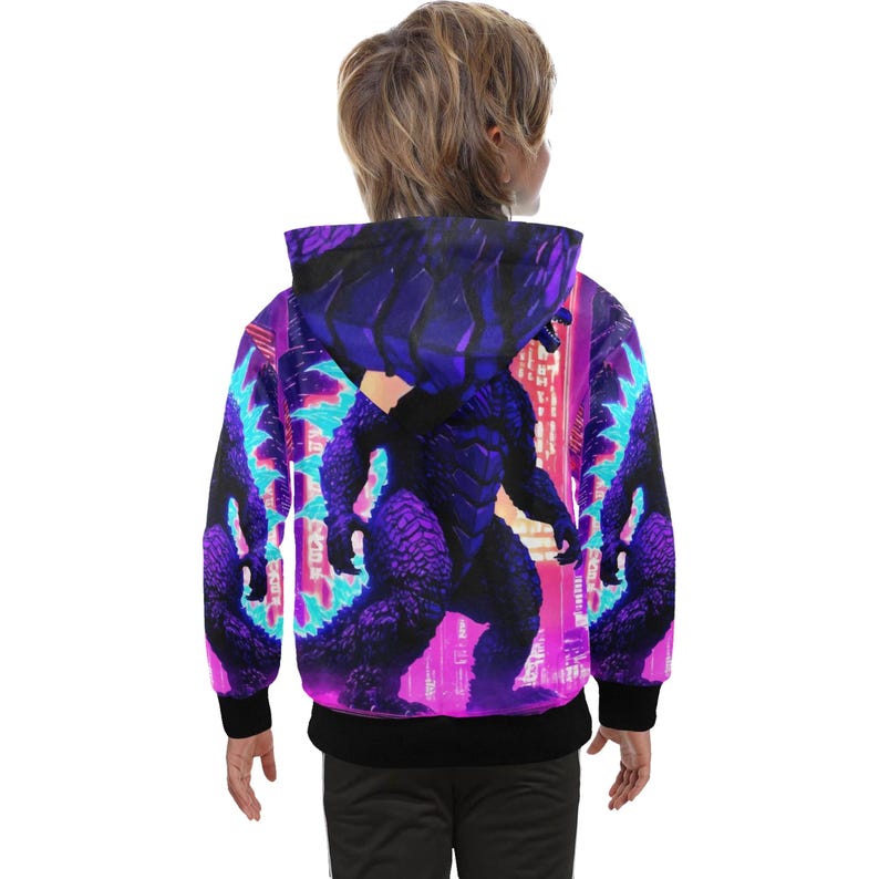 Op de afbeelding: Een zwarte hoodie met een paarse en roze grafische print van een monster met een skyline op de achtergrond.