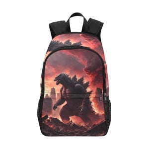 May include: A black backpack featuring a graphic print of a large monster standing in a city amidst a fiery red and orange sky. The bag includes black shoulder straps, a top handle, and side mesh pockets, with a zippered main compartment and front pocket.