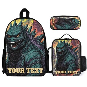 May include: A three-piece set featuring a backpack, pencil case, and lunch bag. Each item displays a green and black Godzilla graphic against a cityscape backdrop. The text "YOUR TEXT" is printed on the backpack and lunch bag.