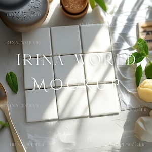 May include: A bright, overhead shot of a white square tile mockup with the text "IRINA WORLD MOCKUP" overlaid. The scene includes a gold spoon, small bowls, and green leaves, creating a clean, minimalist aesthetic.