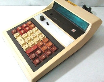 Könnte beinhalten: Ein beiger und brauner Vintage-Rechner mit einem blauen Digitaldisplay. Der Rechner hat eine Vielzahl von Tasten, darunter Zahlen, Operatoren und Funktionen. Der Rechner ist in gutem Zustand und scheint funktionsfähig zu sein.