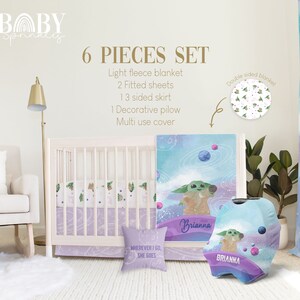 May include: A six-piece baby crib bedding set featuring a space-themed design with a green alien character. The set includes a light fleece blanket, two fitted sheets, a three-sided skirt, a decorative pillow, and a multi-use cover. The bedding is decorated with a watercolor-style galaxy print with planets, stars, and a green alien character. The pillow has the text "WHEREVER I GO, SHE GOES". The multi-use cover has the name "Brianna" printed on it.