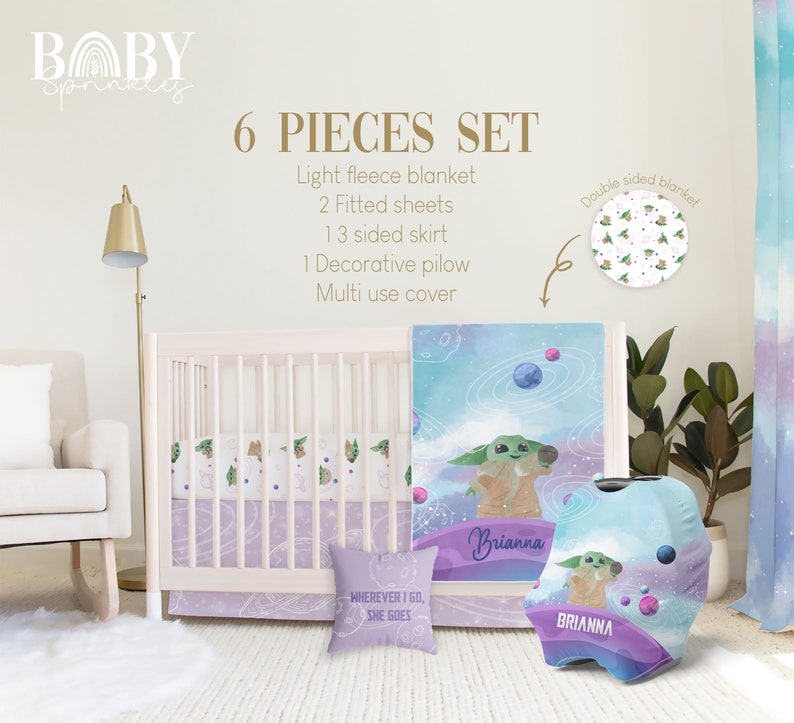 May include: A six-piece baby crib bedding set featuring a space-themed design with a green alien character. The set includes a light fleece blanket, two fitted sheets, a three-sided skirt, a decorative pillow, and a multi-use cover. The bedding is decorated with a watercolor-style galaxy print with planets, stars, and a green alien character. The pillow has the text "WHEREVER I GO, SHE GOES". The multi-use cover has the name "Brianna" printed on it.