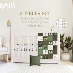 Puede incluir: Un juego de ropa de cama para bebé de 3 piezas con temática de bosque. El juego incluye una manta de microfibra ligera, una almohada decorativa y una sábana ajustable. La manta presenta un diseño de patchwork con un ciervo, patos y flechas en tonos verdes y marrones. La almohada es de color verde sólido con una textura sutil. La sábana ajustable tiene un patrón repetido de ciervos, patos y flechas. El texto "ZACK" aparece en la manta y la sábana ajustable.