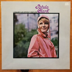 May include: Album cover featuring Petula Clark in a pink raincoat with a hood. The title "I Couldn't Live Without Your Love" is printed below her name in a stylized font. The background is a blurred outdoor scene.