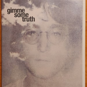 May include: A DVD cover with a black and white photo of John Lennon. The text on the cover reads "the making of john lennon's imagine album" and "gimme some truth".