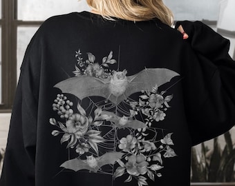 May include: Black sweatshirt with a graphic print of bats and flowers in a gray and white color scheme.