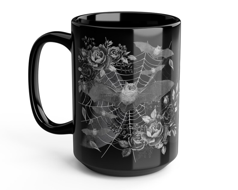 Pu&ograve; includere: Tazza in ceramica nera con un design bianco di pipistrelli, rose e una ragnatela.