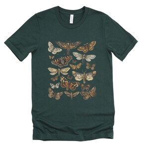 May include: A dark green t-shirt with a print of various moths and butterflies in shades of brown, white, and black.