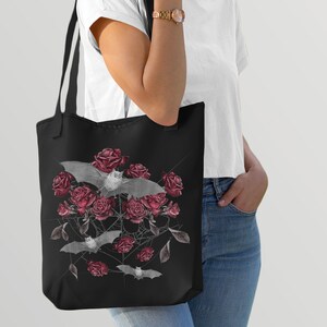 May include: Black tote bag with a design of white bats flying over a cluster of red roses and a spiderweb.