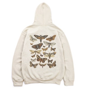 May include: A cream-coloured hooded sweatshirt with a print of various moths and butterflies on the back.