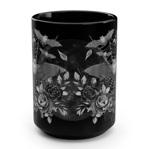 Pu&ograve; includere: Tazza in ceramica nera con un design bianco di pipistrelli, rose e luna piena. Il design &egrave; simmetrico e ha un'estetica gotica.