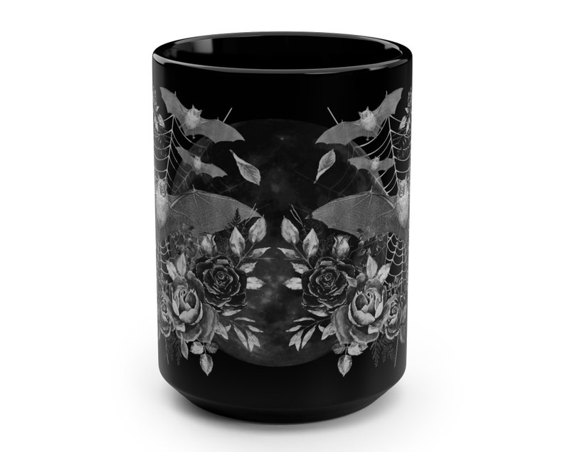 Pu&ograve; includere: Tazza in ceramica nera con un design bianco di pipistrelli, rose e luna piena. Il design &egrave; simmetrico e ha un'estetica gotica.