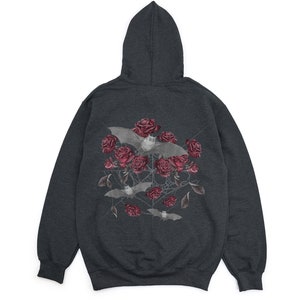 May include: Dark gray hoodie featuring a graphic of bats, red roses, and a spiderweb design. The hooded sweatshirt has a drawstring and a kangaroo pocket. The graphic is centered on the back of the hoodie.