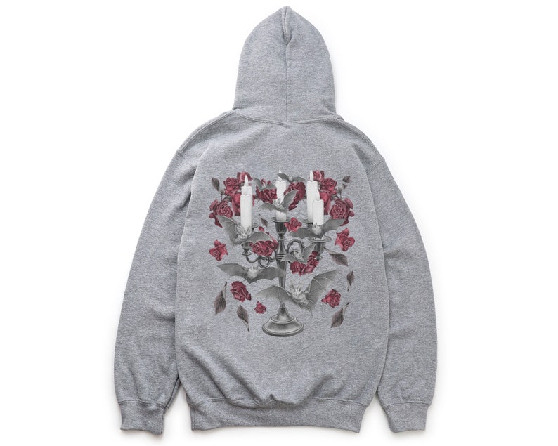 May include: A gray hooded sweatshirt with a graphic print of a candelabra with candles and roses. The candelabra is surrounded by bats and leaves.