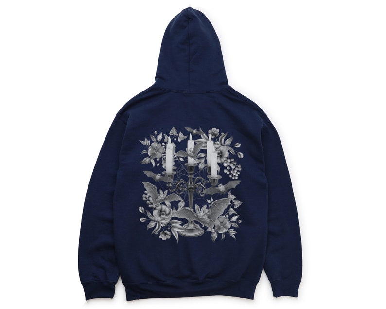 May include: A navy blue hooded sweatshirt featuring a graphic print of a candelabra with three lit candles, bats, and flowers. The graphic is in shades of grey.
