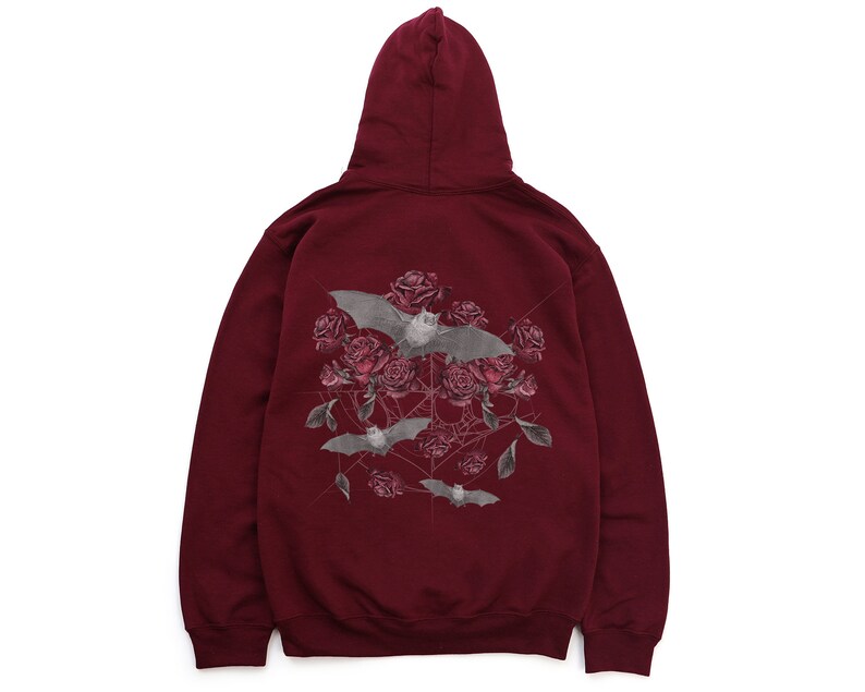 May include: Burgundy hoodie with a hood. The back features a graphic of gray bats, red roses, and a spiderweb design. The bats are in flight, and the roses are in full bloom. The hoodie is made of a soft material.