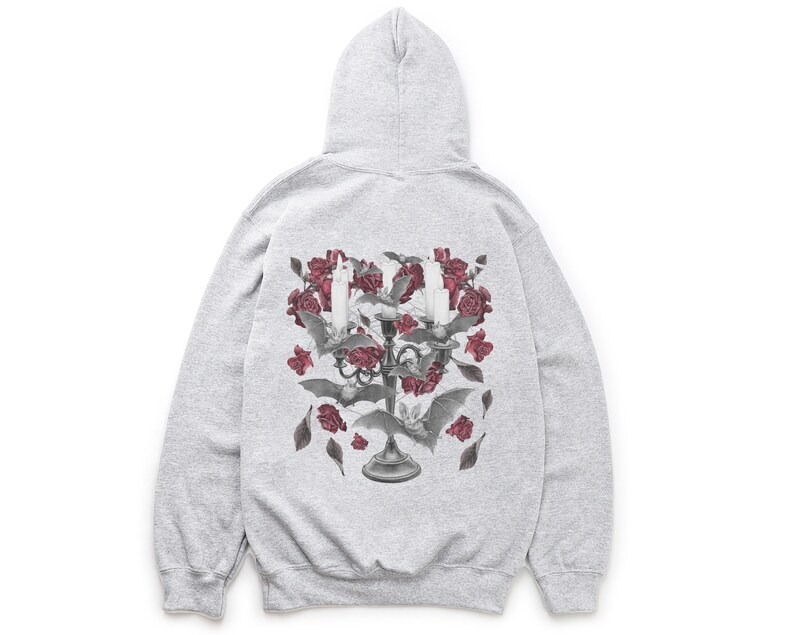 May include: A gray hooded sweatshirt with a graphic print of a candelabra with red roses and bats. The candelabra is surrounded by a cluster of red roses and bats.