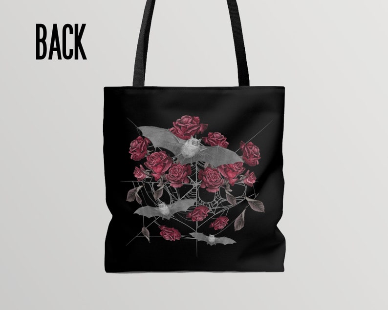 May include: Black tote bag with a design of bats flying around red roses and a spider web. The design is in a gray and white color scheme.