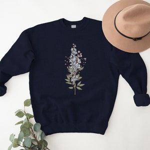 May include: A navy blue sweatshirt with a floral design featuring white flowers and green leaves.