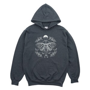 May include: A dark grey hooded sweatshirt with a white graphic print of a moth and moon. The moth is surrounded by smaller moths and flowers.
