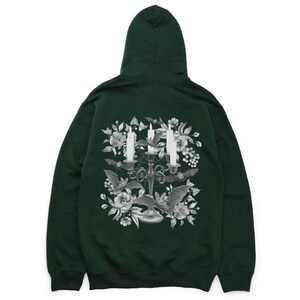May include: A dark green hooded sweatshirt featuring a graphic print of a candelabra with three candles, bats, and flowers. The graphic is in shades of grey.