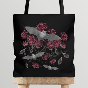 May include: Black tote bag with a design of bats and red roses on a black background.