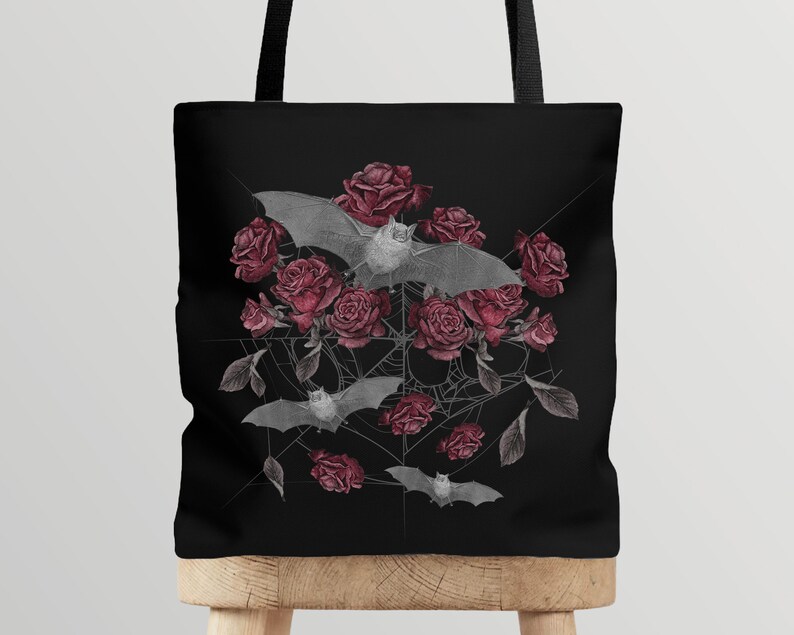 May include: Black tote bag with a design of bats and red roses on a black background.