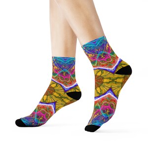 May include: A pair of colourful socks with a psychedelic pattern featuring blue, yellow, pink, and red hues. The socks have a black heel and toe.