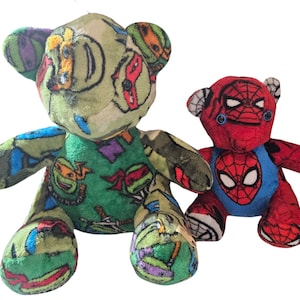 May include: Two plush teddy bears. One is green with a Teenage Mutant Ninja Turtles pattern. The other is red and blue, resembling Spider-Man. Both have embroidered features and are designed to look like bears.