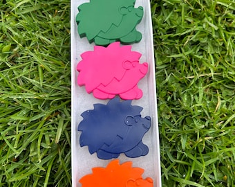 May include: Five hedgehog shaped crayons in a white box. The crayons are red, green, pink, blue, and orange.