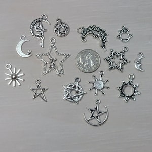 May include: A collection of silver charm pendants featuring various celestial and mystical symbols, including stars, moons, suns, and pentagrams.
