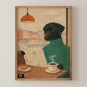 Puede incluir: Impresión enmarcada de un Labrador Retriever negro con un suéter verde leyendo un periódico en un café. Una taza de café y un cruasán están sobre la mesa. El fondo muestra un paisaje urbano y una lámpara naranja.