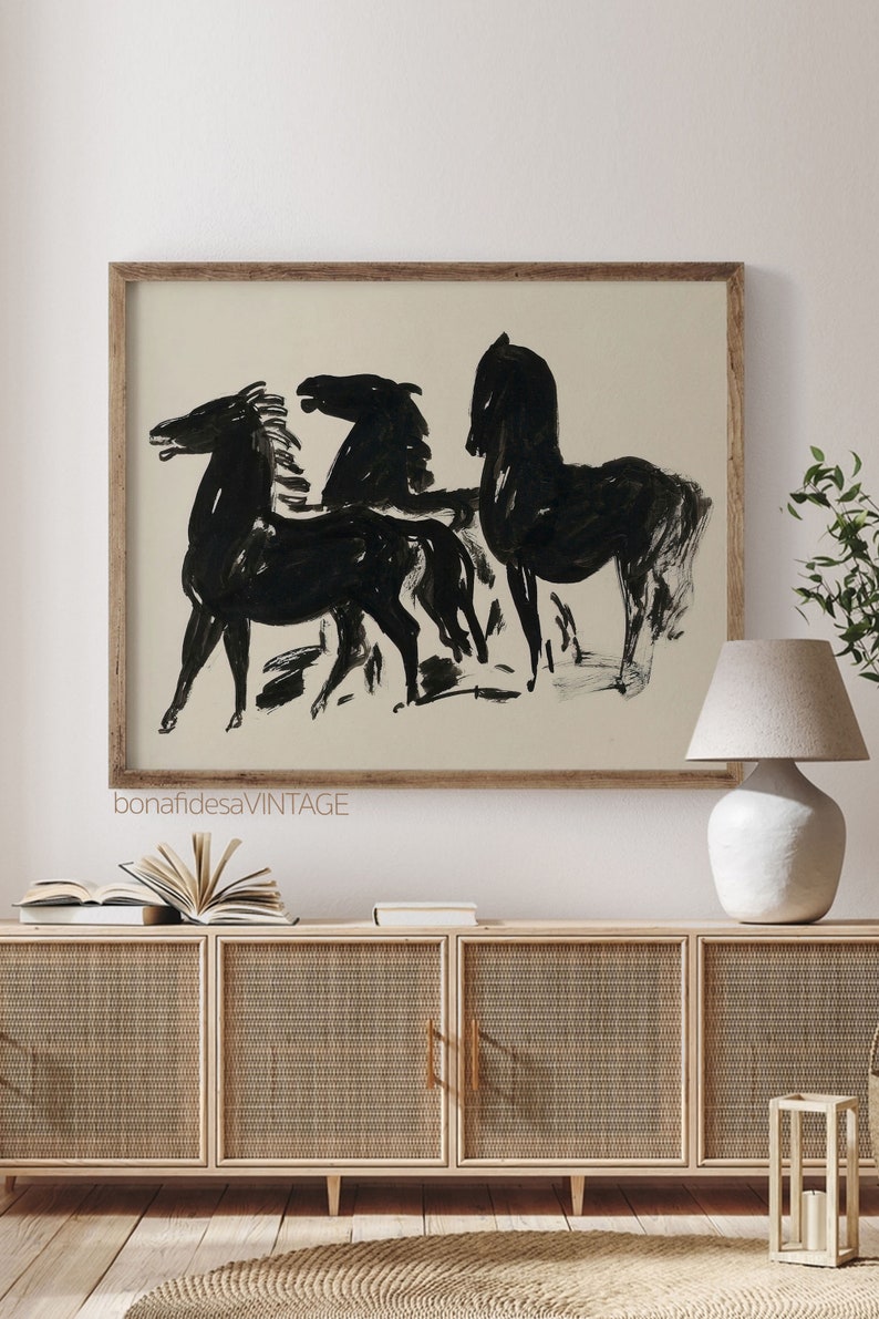 May include: A framed black and white illustration of three horses in a minimalist style. The horses are drawn in a simple, abstract style with bold lines. The background is a light beige color.